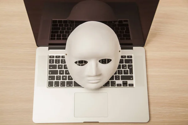 Kavramsal fotoğraf, maske bir hacker attac bir sembolü olarak bir dizüstü bilgisayar