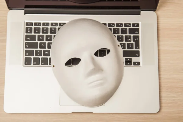 Kavramsal fotoğraf, maske bir hacker attac bir sembolü olarak bir dizüstü bilgisayar