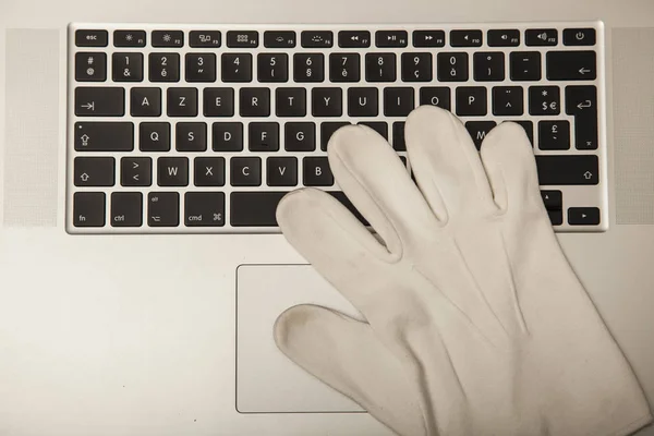 Conceptual photo, the glove on the keyboard shows the possibilit