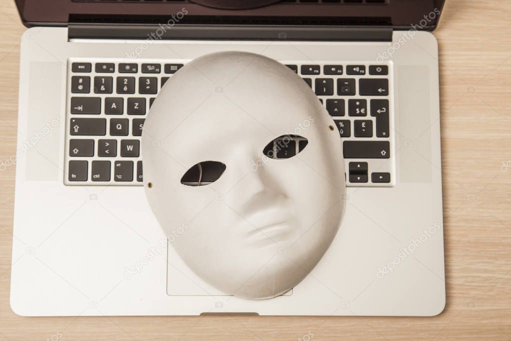 Conceptual photo, mask on a laptop as a symbol of a hacker attac