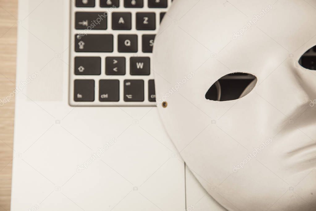 Conceptual photo, mask on a laptop as a symbol of a hacker attac