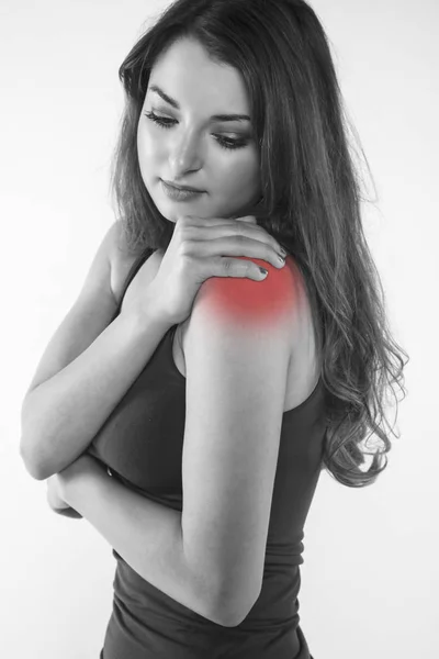 Una mujer joven está luchando con el dolor, aislado en el fondo —  Fotos de Stock