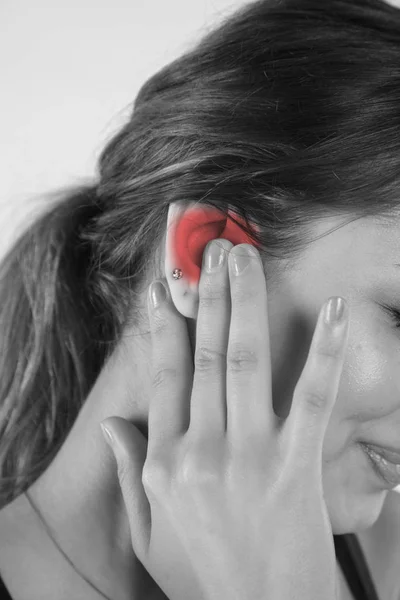 Una mujer joven está luchando con el dolor, aislado en el fondo —  Fotos de Stock