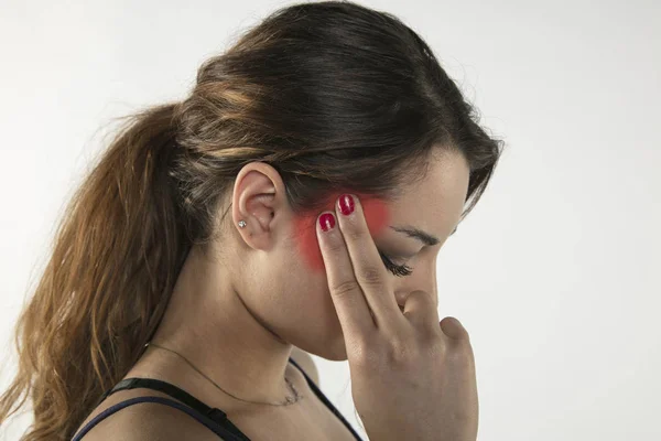 Una giovane donna sta lottando con il dolore, isolata sullo sfondo — Foto Stock