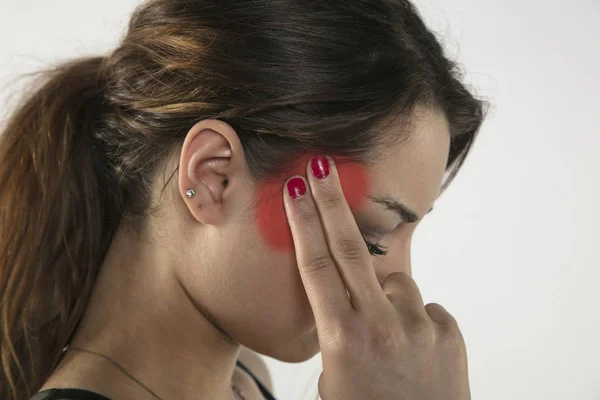 Eine junge Frau kämpft mit Schmerzen, isoliert im Hintergrund — Stockfoto