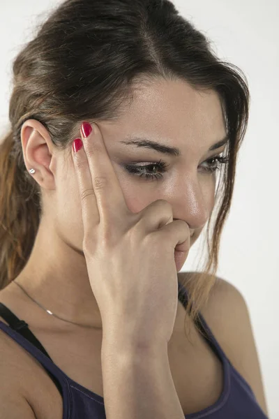 Eine junge Frau kämpft mit Schmerzen, isoliert im Hintergrund — Stockfoto