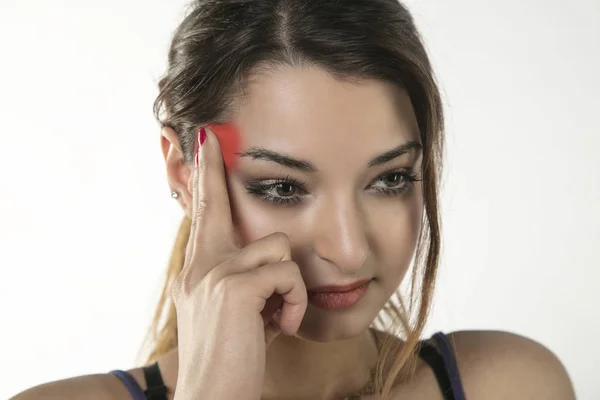 Uma jovem mulher está lutando com dor, isolada no fundo — Fotografia de Stock