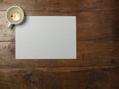 Kahve fincanı, masa manzarası ve boş bir kağıt parçası.