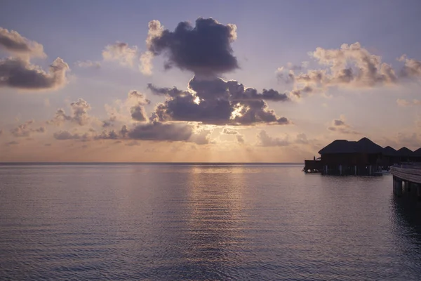 Coucher de soleil sur l'océan, les rayons du soleil se brisent à travers le clo — Photo