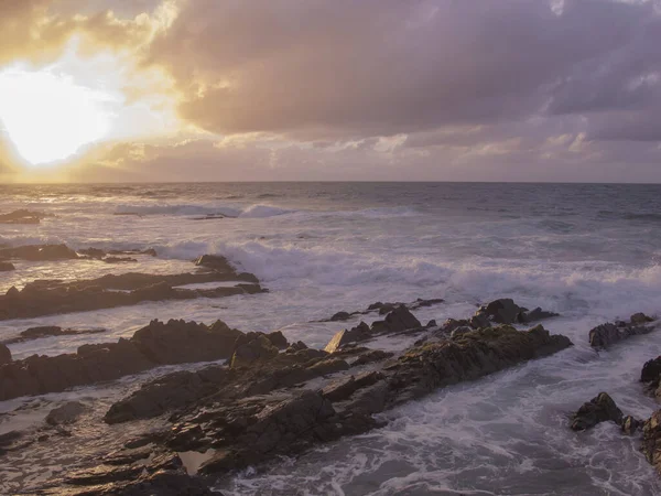 Kamenné pobřeží, vodní vlny a krásný západ slunce — Stock fotografie