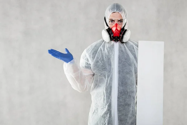 virologist in protective clothing holds advertising space in his hands