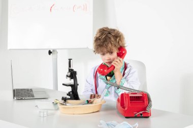 Genç doktor bir telefon konuşması sırasında kulaklıklara bağırıyor.