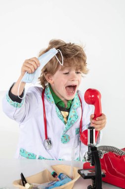 Genç doktor bir telefon konuşması sırasında kulaklıklara bağırıyor.