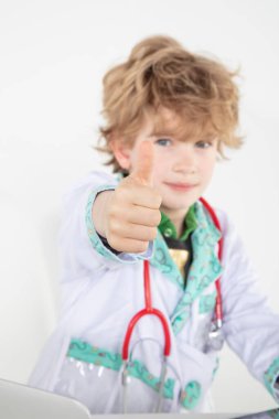 Meşgul genç doktor, şans simgesi olarak baş parmağını kaldırdı.