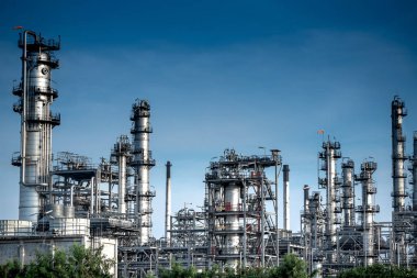Yakından bakıldığında petrol ve gaz endüstriyel rafineri bölgesi, bulutlu gökyüzünde büyük bir petrol depolama tankından valflı ekipman petrol boru hattı çeliği. - Resim