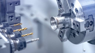 Matkap araçlarıyla metal çubukları delen Cnc torna makinesi