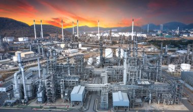Petrol ve gaz rafineri endüstrisinin panoramik manzarası, alacakaranlıkta dağlar.