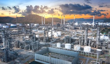 Petrol ve gaz rafineri endüstrisinin panoramik manzarası, alacakaranlıkta dağlar.