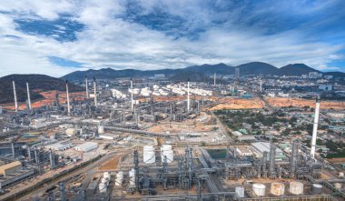 Petrol ve gaz rafineri endüstrisinin panoramik manzarası, alacakaranlıkta dağlar.