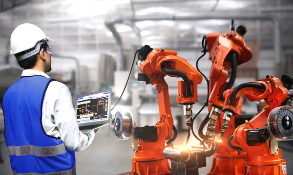 로봇팔은 산업에 사용되고 엔지니어는 기능높은 정확성 공장에서 용접을 로열티 프리 스톡 사진