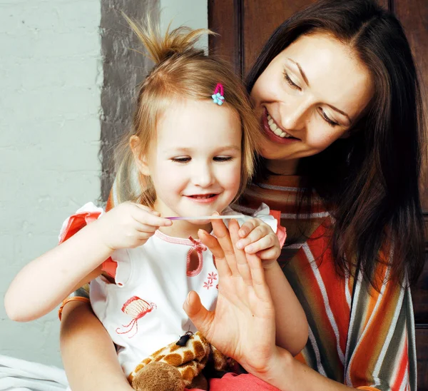 mother with daughter together in bed smiling, happy family close up, lifestyle people concept, cool real modern family