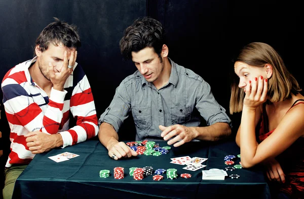 two modern hipster guys and woman playing poker, home company of friends, lifestyle people concept