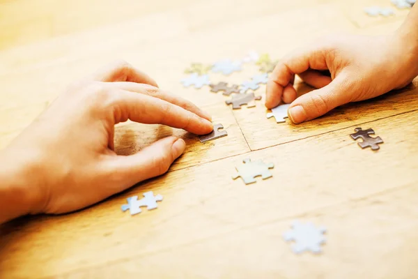 little kid playing with puzzles on wooden floor together with pa