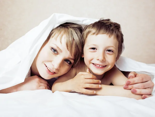 mother with daughter together in bed smiling, happy family close up, lifestyle people concept, cool real modern family