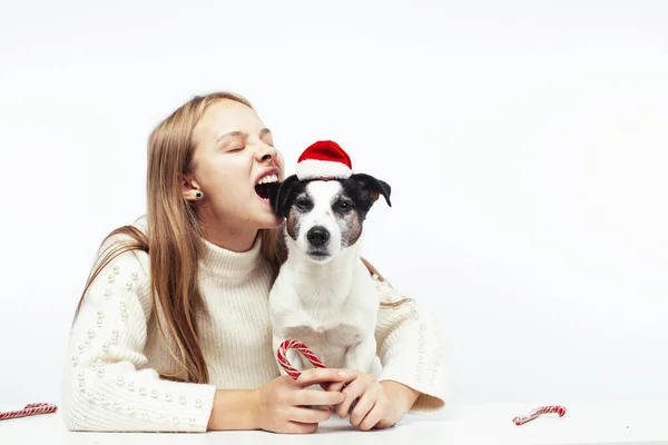 Pretty young blond girl with her little cute dog wearing Santas red hat at Christmas holiday isolated on white background, lifestyle people concept — Stock Image Pretty young blond girl with her little cute dog wearing Santas red hat at Christmas holiday isolated on white background, lifestyle people concept Royalty Free Stock Images