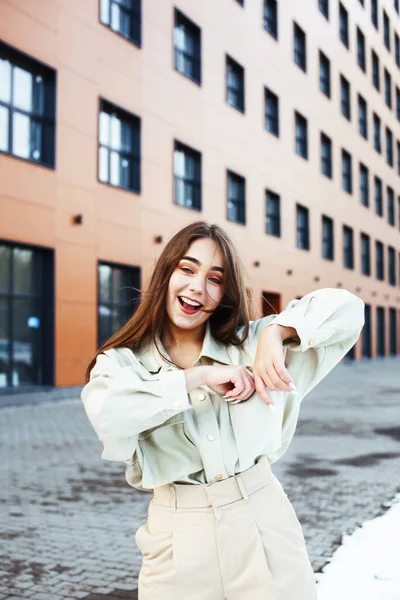 young pretty teenage girl posing cheerful happy smiling wearing street style outside in europe city, lifestyle people concept