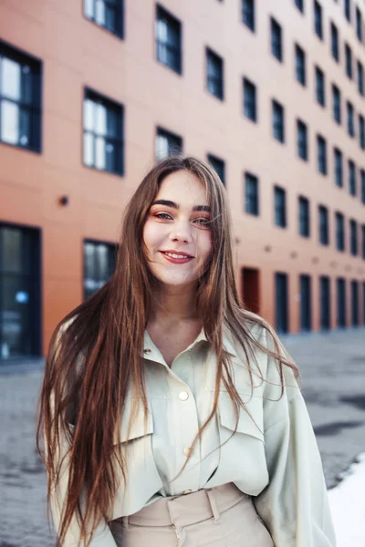 young pretty teenage girl posing cheerful happy smiling wearing street style outside in europe city, lifestyle people concept