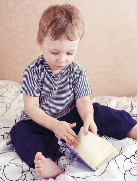 little cute boy reading book in bed at home, lifestyle poeple during corona virus isolation