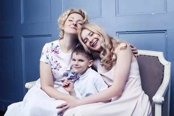 happy smiling blond family together posing cheerful on blue background, generation concept. lifestyle people