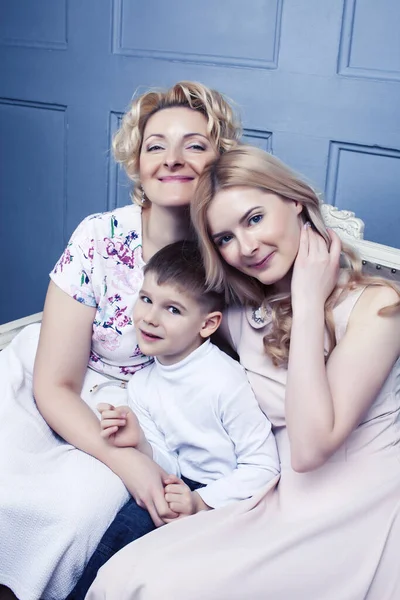 happy smiling blond family together posing cheerful on blue background, generation concept. lifestyle people