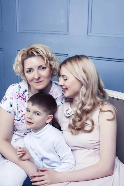 happy smiling blond family together posing cheerful on blue background, generation concept. lifestyle people