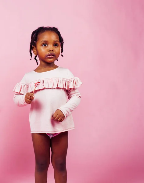 little cute african girl posing cheerful inocent on pink background, lifestyle people concept
