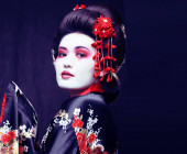 fiatal csinos igazi gésa kimono sakura és dekoráció fekete háttér