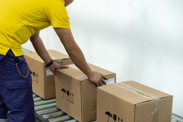 Um homem de t-shirt amarelo a trabalhar num armazém . — Fotografia de Stock