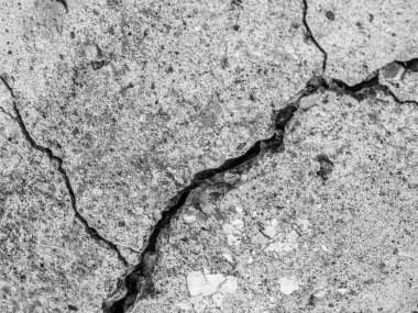 Yüksek çözünürlüklü eski beton çatlaklara ve zaman ve hava koşullarından kaynaklanan doğal yıkıma sahip. Renksiz, tek renkli, siyah beyaz fotoğraf.