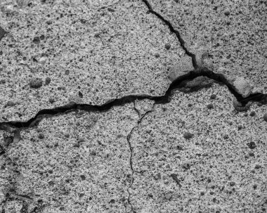 Yüksek çözünürlüklü eski beton çatlaklara ve zaman ve hava koşullarından kaynaklanan doğal yıkıma sahip. Renksiz, tek renkli, siyah beyaz fotoğraf.