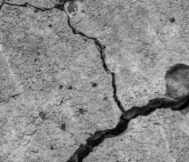 Yüksek çözünürlüklü eski beton çatlaklara ve zaman ve hava koşullarından kaynaklanan doğal yıkıma sahip. Renksiz, tek renkli, siyah beyaz fotoğraf.