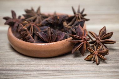 Tohumlu ve tohumsuz yıldız, hafif ahşap bir yüzeyde, kil bir tabakta kapalı. Tarif için baharat. güzel resim, arkaplan.
