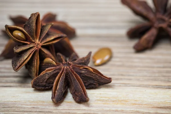 star anise with and without seeds, closed, on a light wooden surface. spice for the recipe. beautiful picture, background.
