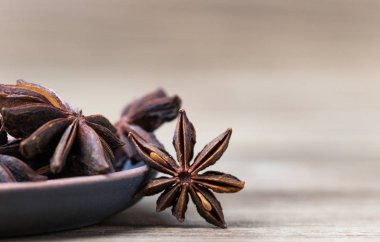 Tohumlu ve tohumsuz bir yıldız, hafif ahşap bir yüzeyde, kil bir kapta. Tarif için baharat. güzel resim, arkaplan.