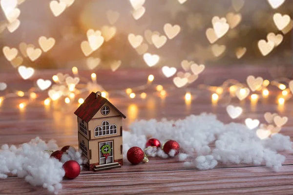 Beautiful toy wooden houses on a wooden background with garlands