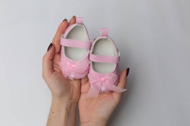 Eldeki kız için küçük pembe bebek sandaletleri