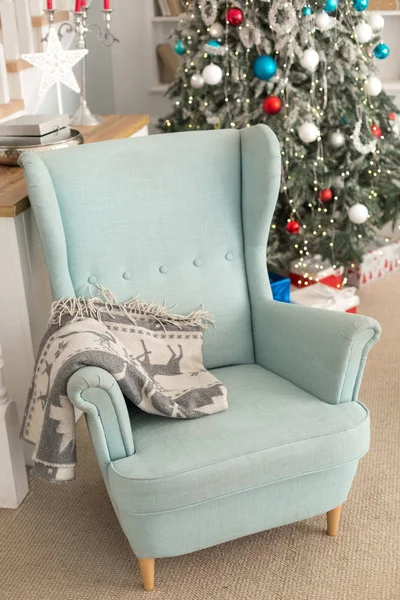 Niebieskie krzesło obok choinki, wnętrze pokoju Bożego Narodzenia. — Zdjęcie stockowe