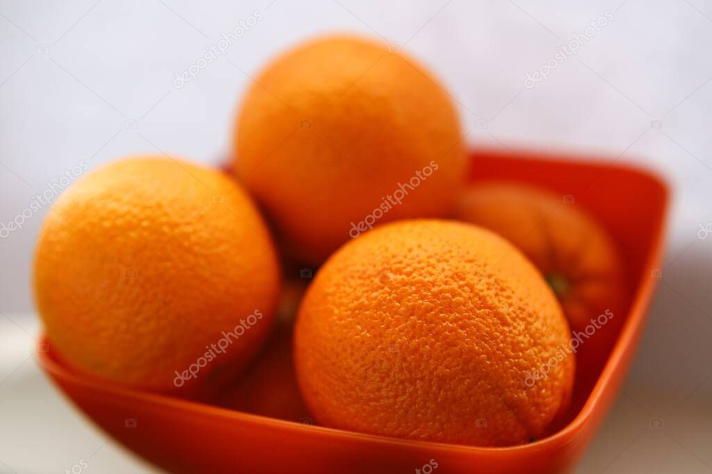 Ripe oranges lie in a plate on a white background. Soft focus. Backgrounds
