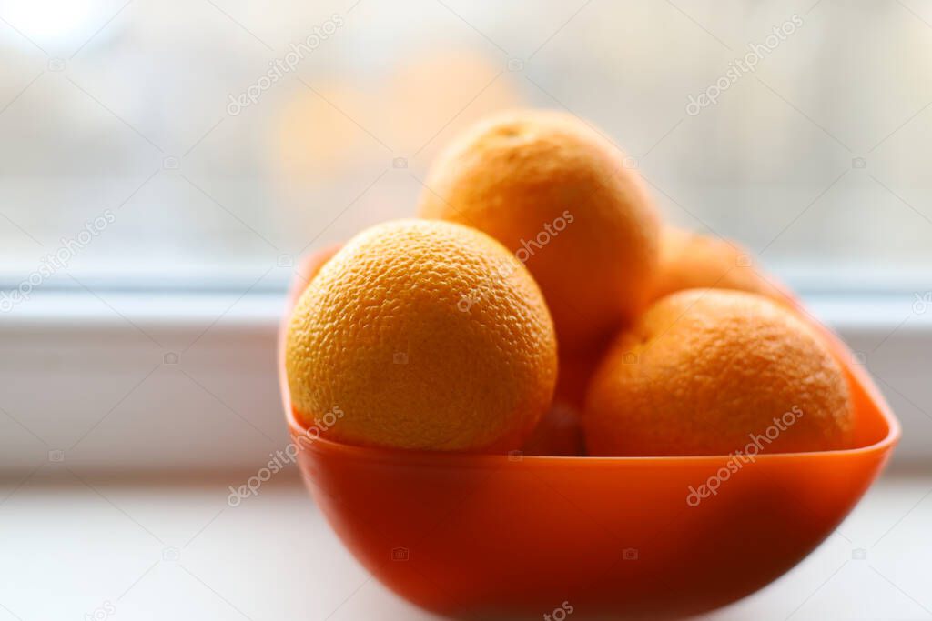 Ripe oranges lie in a plate on a white background. Soft focus. Backgrounds