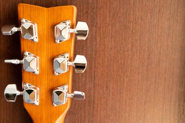 Ahşap bir arka planda akustik gitar yakası. Pin mekanizması. Arkaplan ve dokular